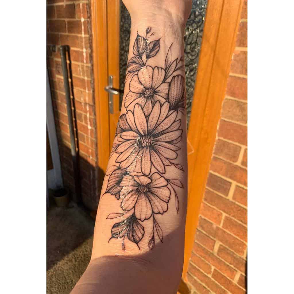 Forearm tattoo of detailed aster flowers and leaves