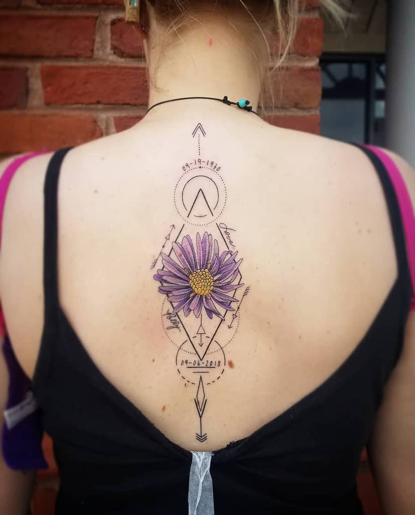 A woman with an aster tattoo and geometric designs on her upper back