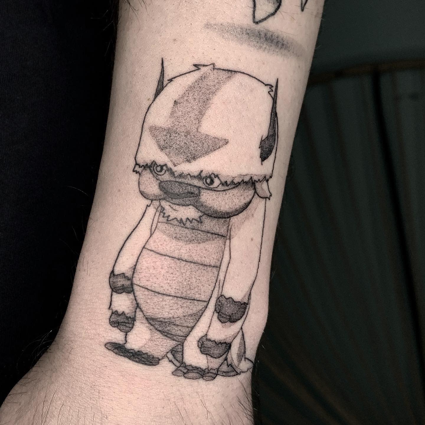Tattoo of Appa depicted in a minimalist style with a dot work technique on the forearm