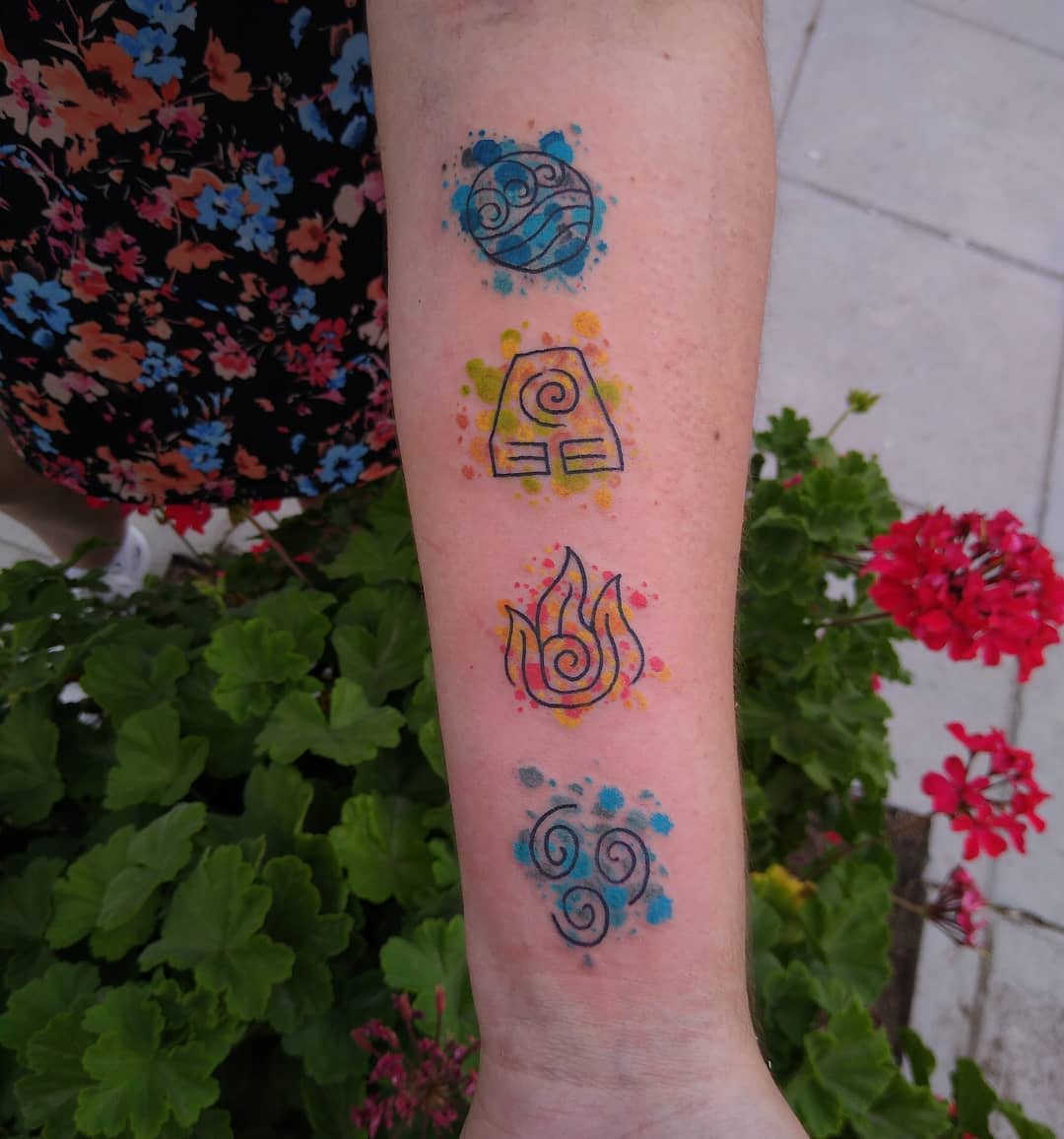 Forearm tattooed with colorful elements: wind, earth, fire, water