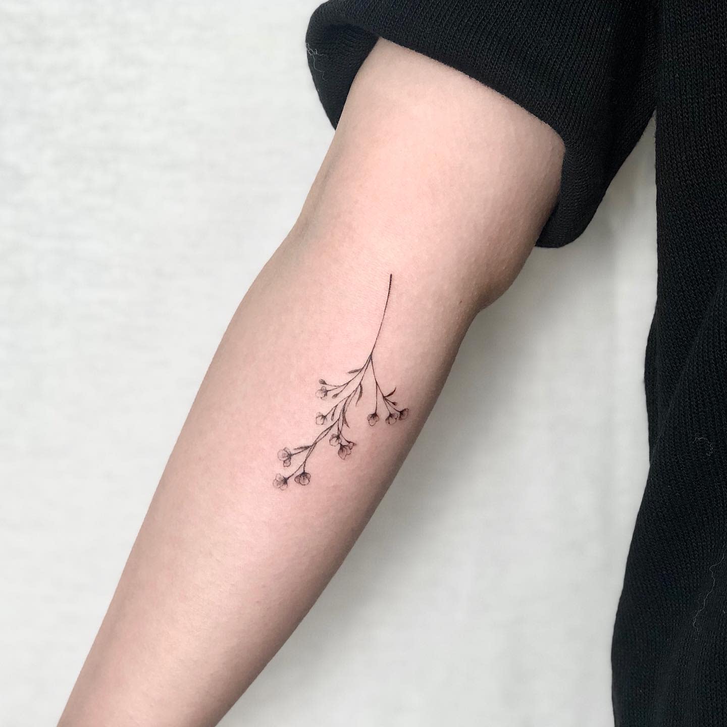 Tattoo of a baby's breath on the inner forearm