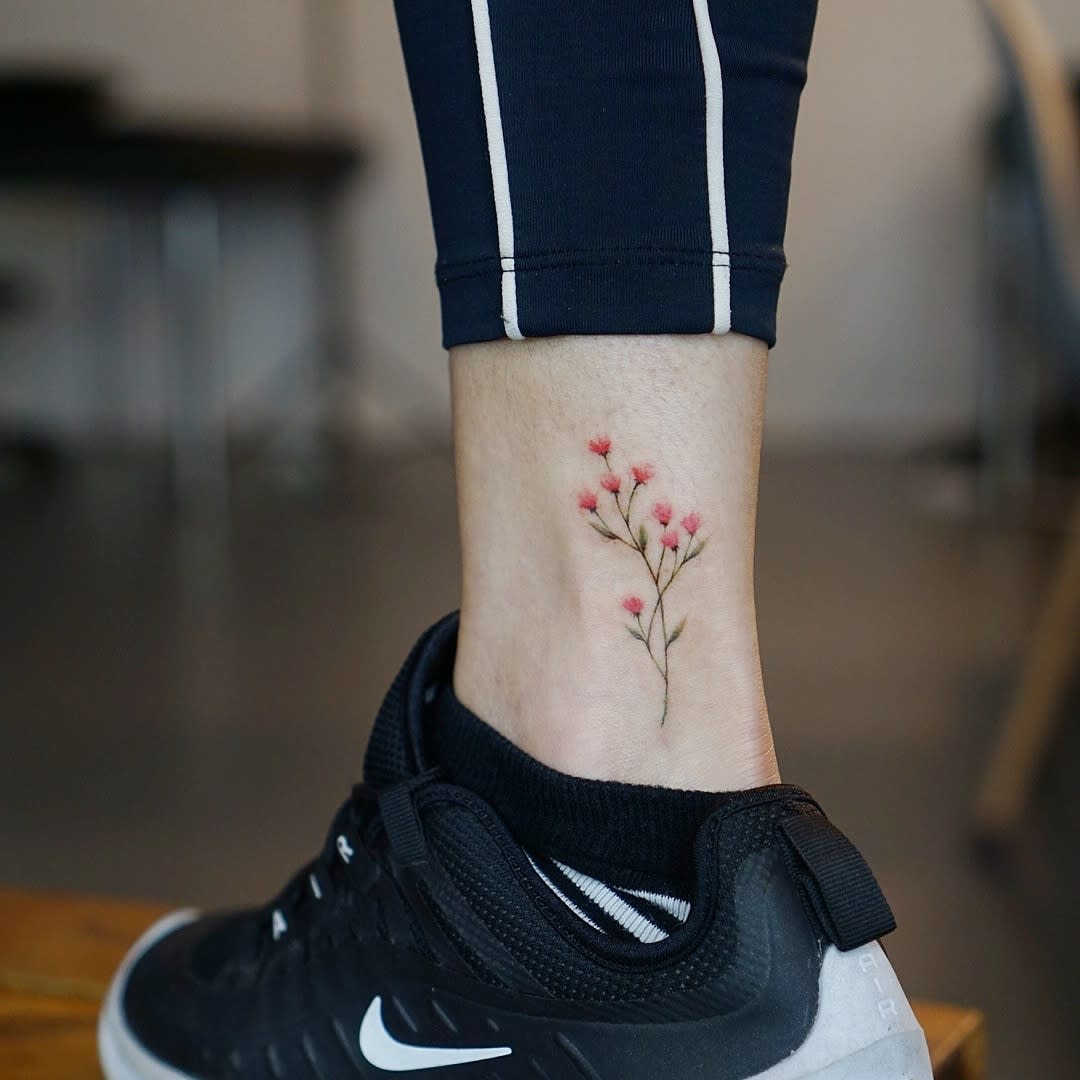 Ankle tattoo of pink baby's breath flowers