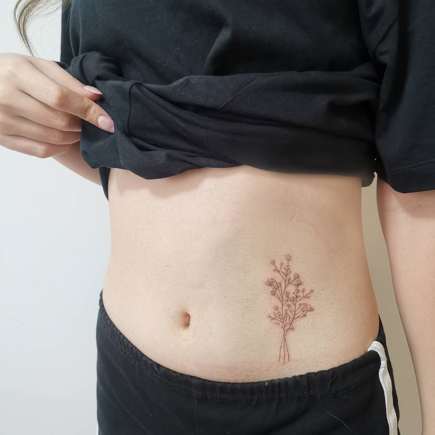 Small baby's breath tattoo on left side torso