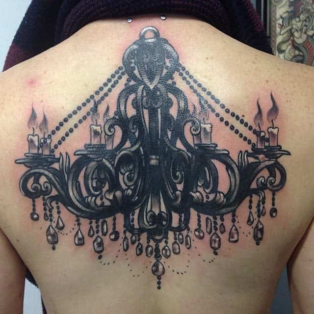 Black and grey tattoo of an intricate chandelier design with candles and hanging beads