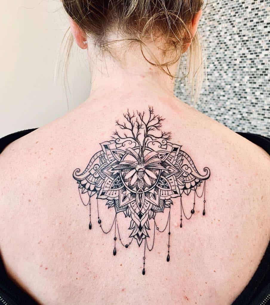 Intricate black ink back tattoo featuring a symmetrical mandala design with a DNA-like structure at the center, chandelier-style beads, and a tree growing from the top