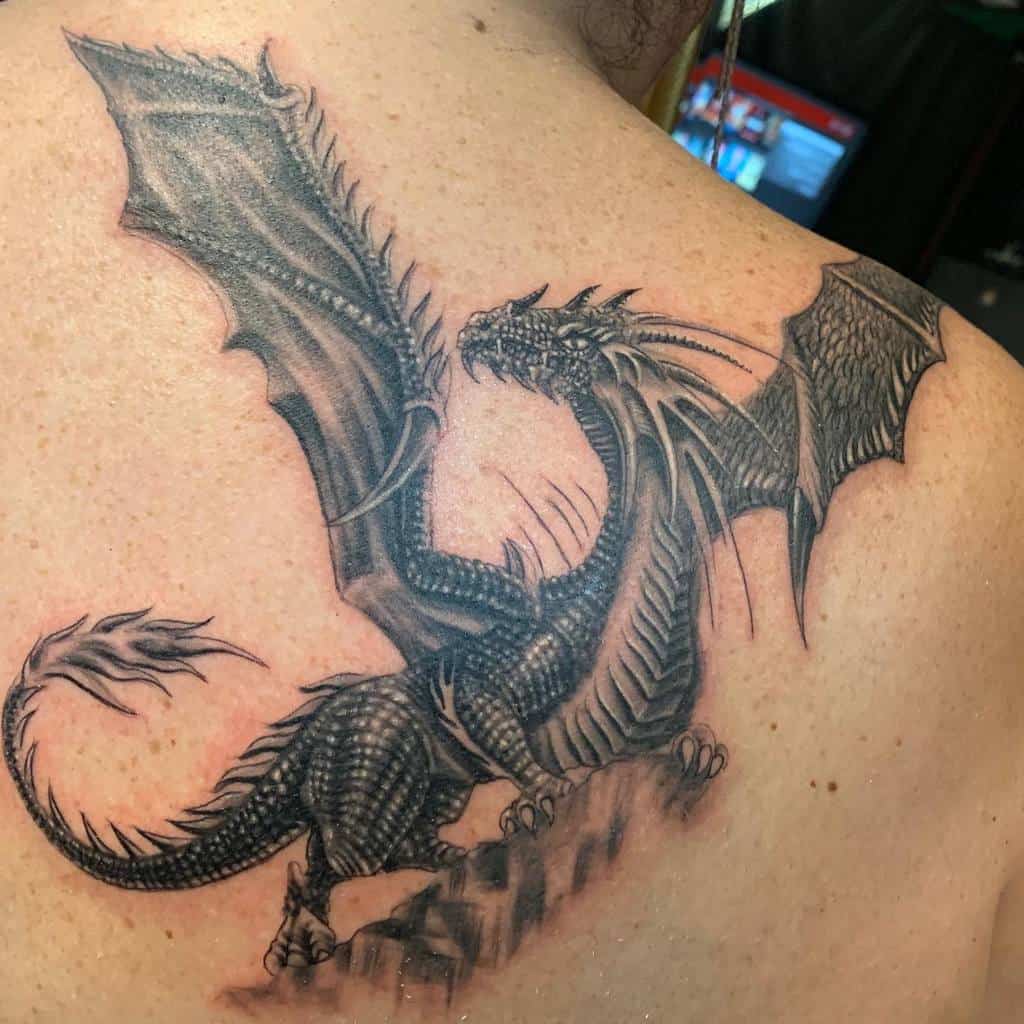 Detailed dragon tattoo with outstretched wings on a woman's back