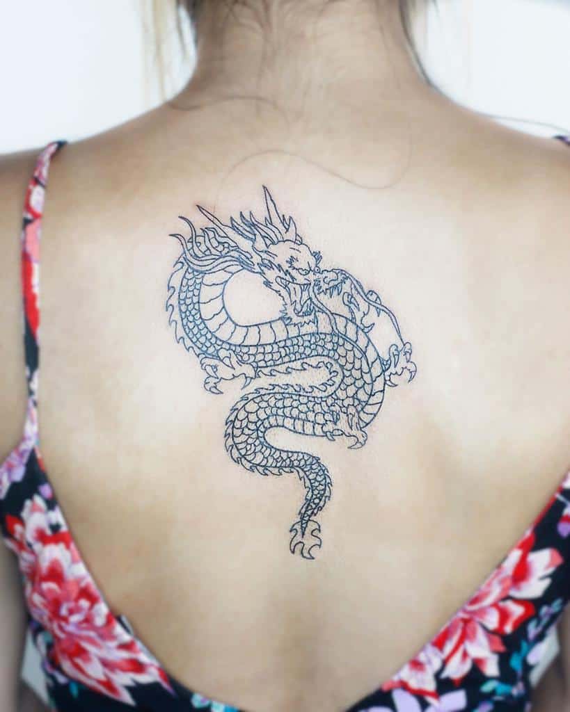 Woman with dragon tattoo on her back