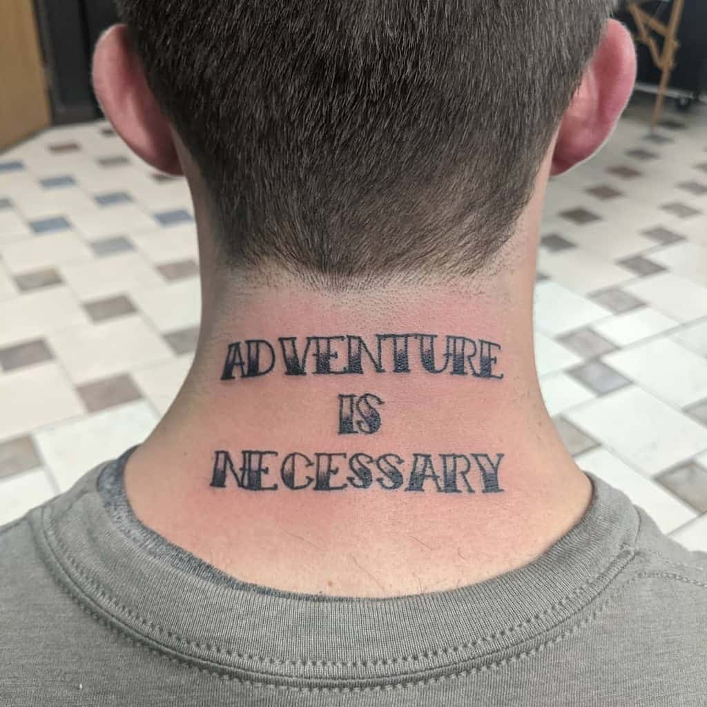 Tattoo on the back of neck that reads "ADVENTURE IS NECESSARY" in bold, black letters