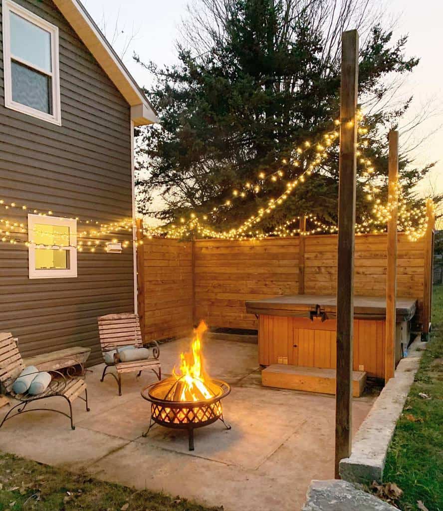 paver backyard patio wood divider fairy lights fire pit