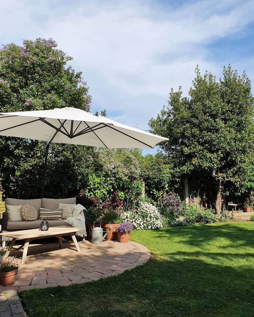 stone paver patio with umbrella and sofa 