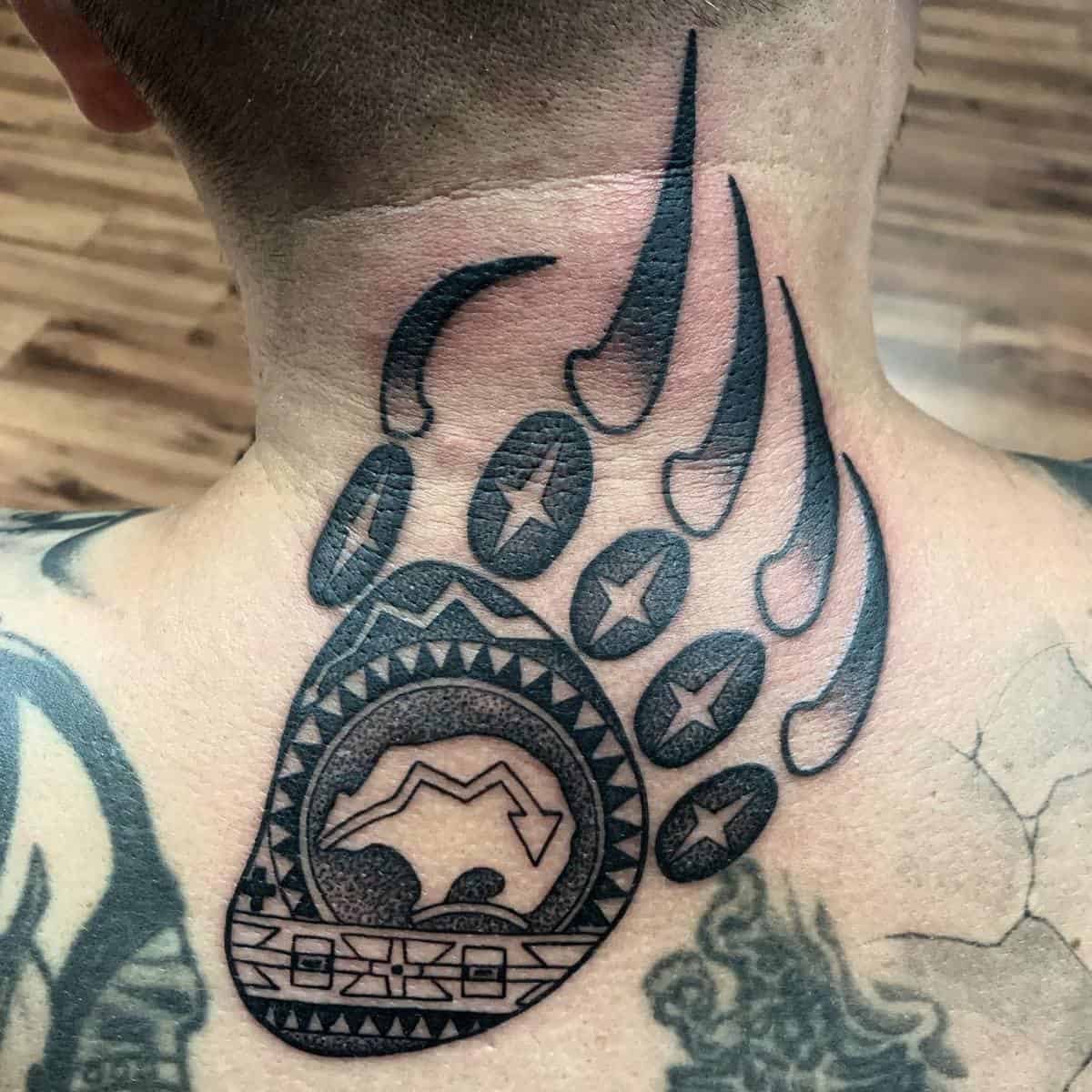 Bear paw tattoo with stars and mountain design on the back of a person's neck