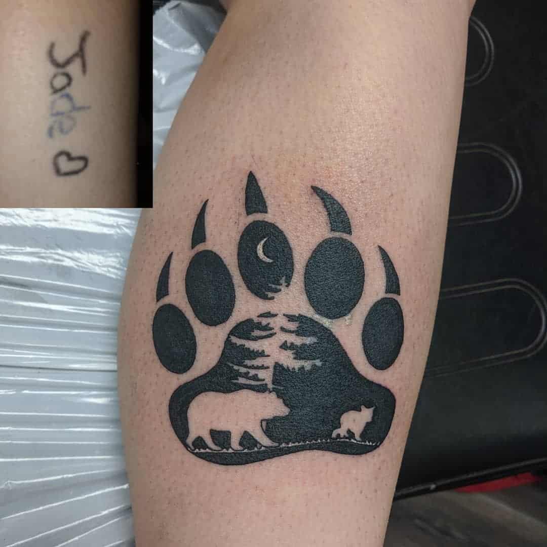 Bear paw tattoo with moon, trees, big bear and cub. 'Jade' text with heart on the side