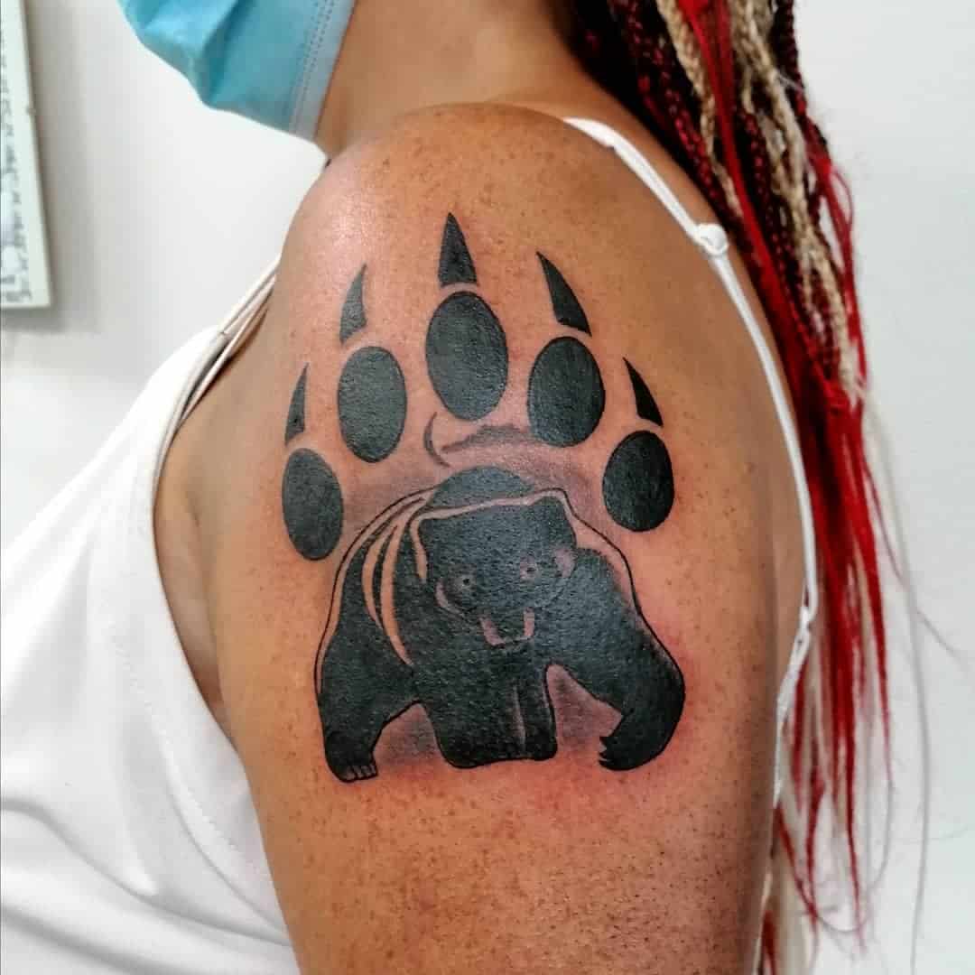 A woman with a bear paw tattoo on her shoulder