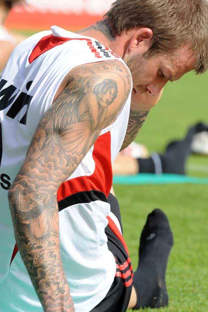 David Beckham's black and gray tattoo of an angels with clouds surrounding it and with texts