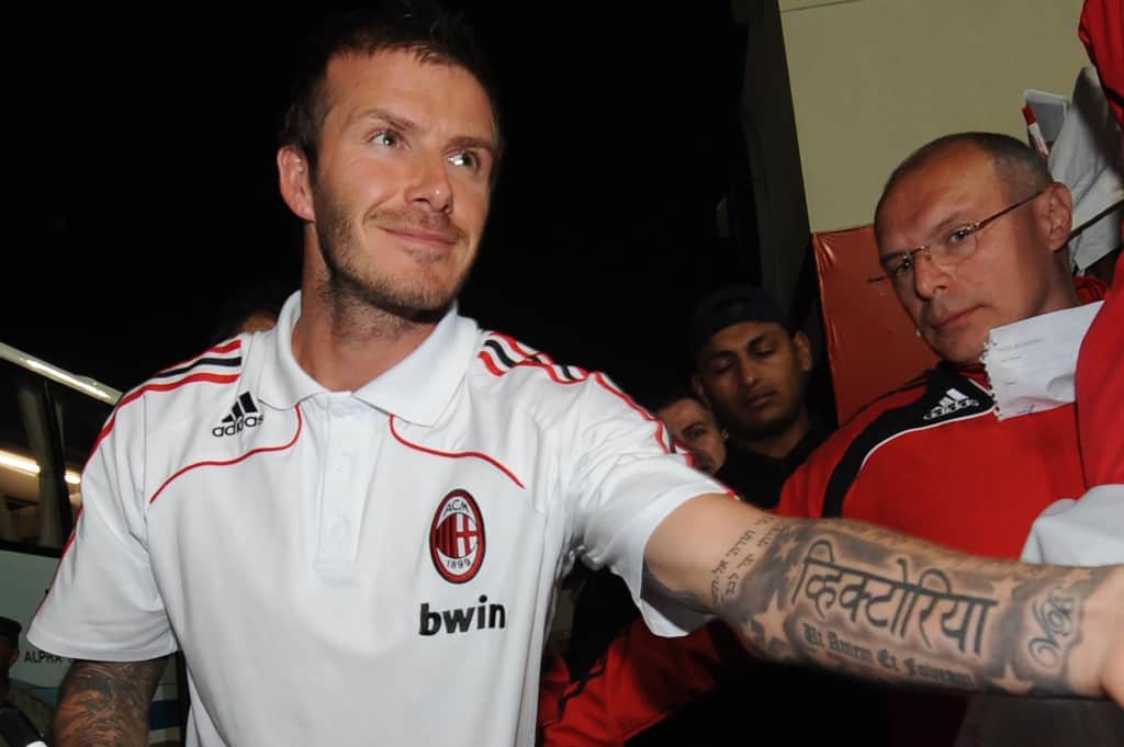 David Beckham's black and gray Sanskrit tattoo of his wife's name 'Victoria' with stars surrounding it