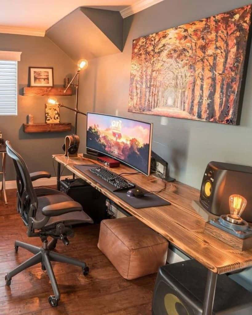 Cozy home office with a computer, ergonomic chair, wooden desk, and forest-themed wall art