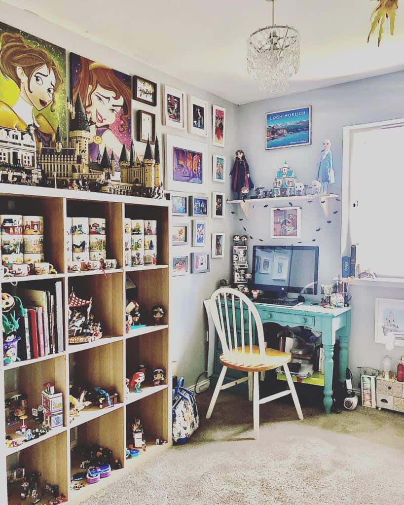 Cozy home office with colorful art, bookshelves, figurines, and a small desk with a computer by the window