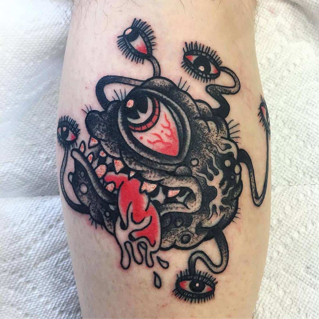 Bold tattoo of a Dungeons & Dragons Beholder with red and black details, featuring multiple eyes and a dripping tongue design