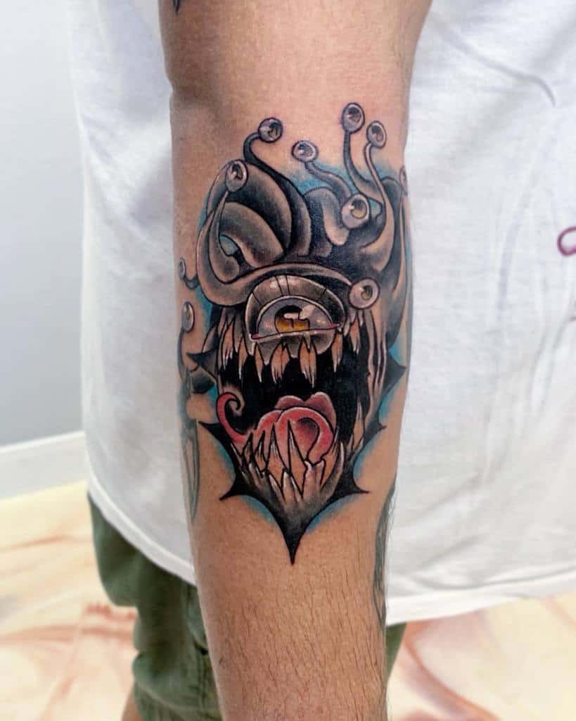 Black and grey tattoo of a Beholder with sharp teeth and intense shading, paired with glowing accents and intricate detailing
