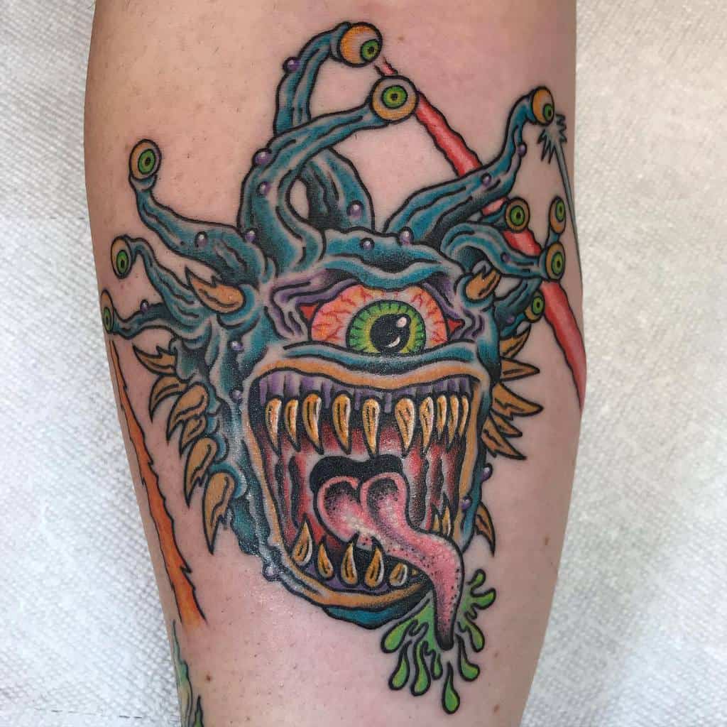 Vibrant Beholder tattoo with a green central eye, fierce tongue, and sharp teeth, radiating energy with bold colors and textures