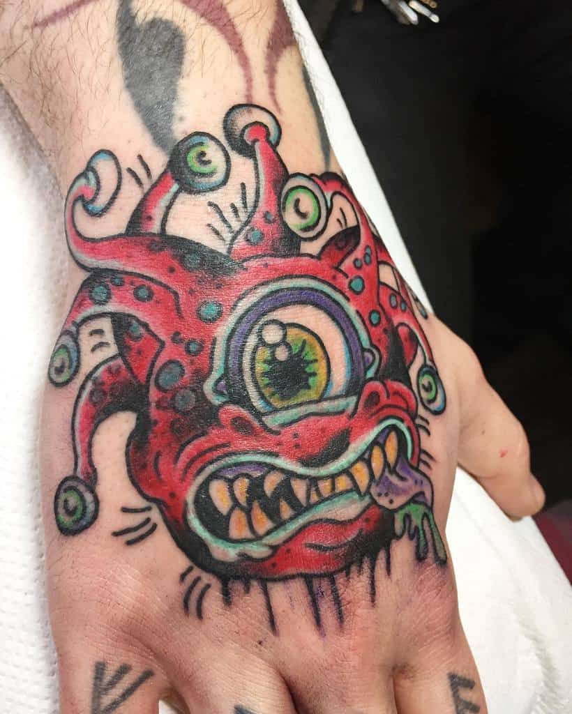 Unique red Beholder hand tattoo with glowing green accents, sharp teeth, and dynamic details for a bold and striking design