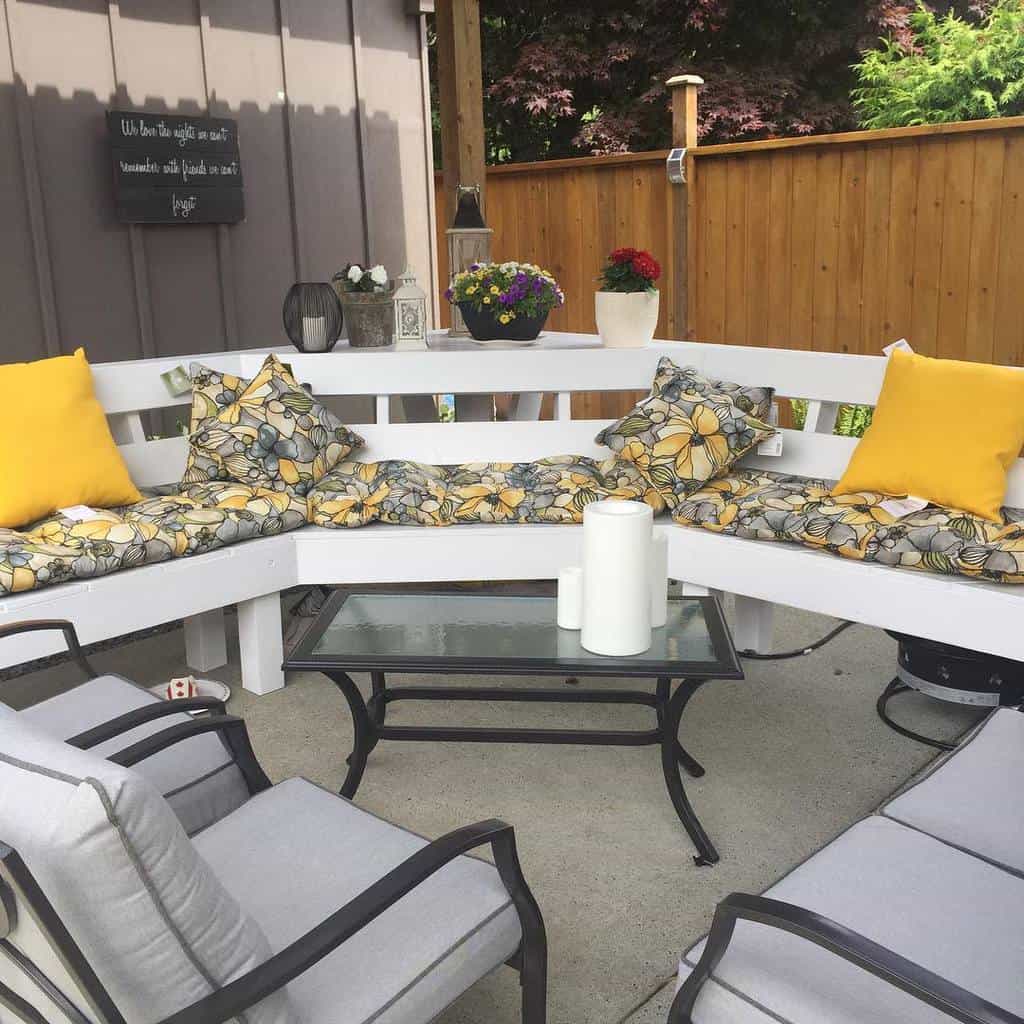 white bench gray outdoor furniture floral pillows