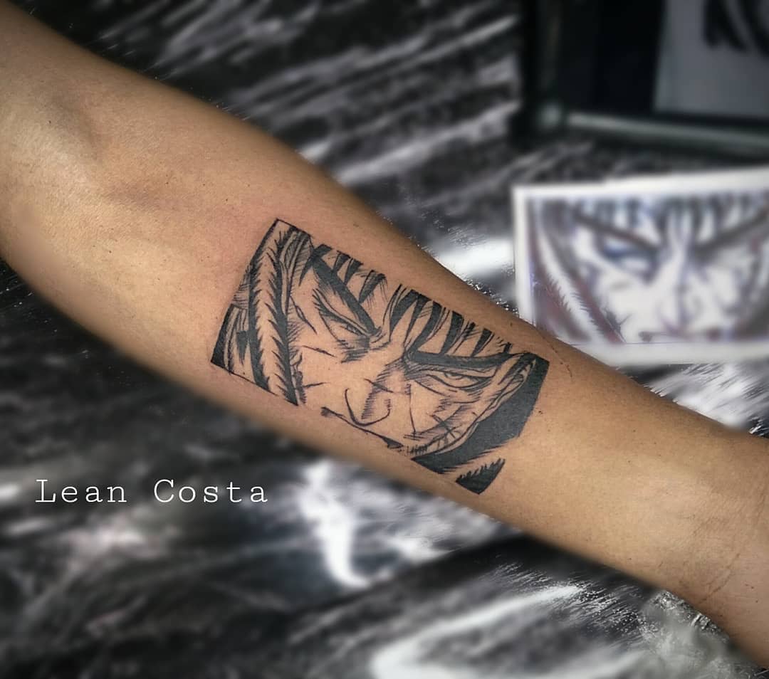 Tattoo of Guts from Berserk on the forearm, showcasing his intense gaze with detailed linework