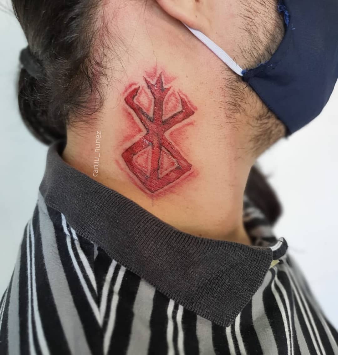 Tattoo of the Brand of Sacrifice from Berserk on the side of the neck, depicted in a vivid red with a raw, scarred effect