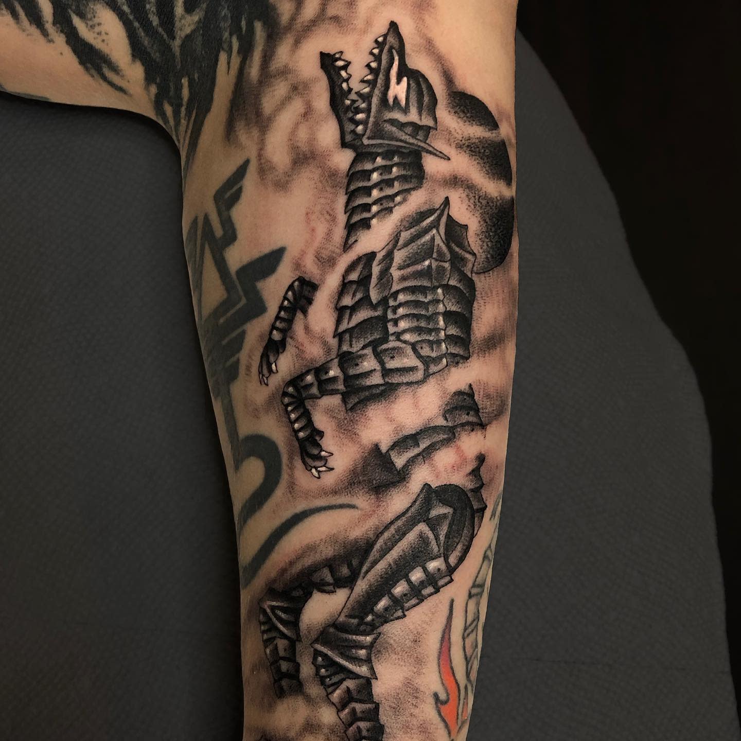 Tattoo of the Berserk Armor in its wolf-like form on the arm, depicted in fragmented pieces with intense shading, capturing the menacing and aggressive nature of the armor