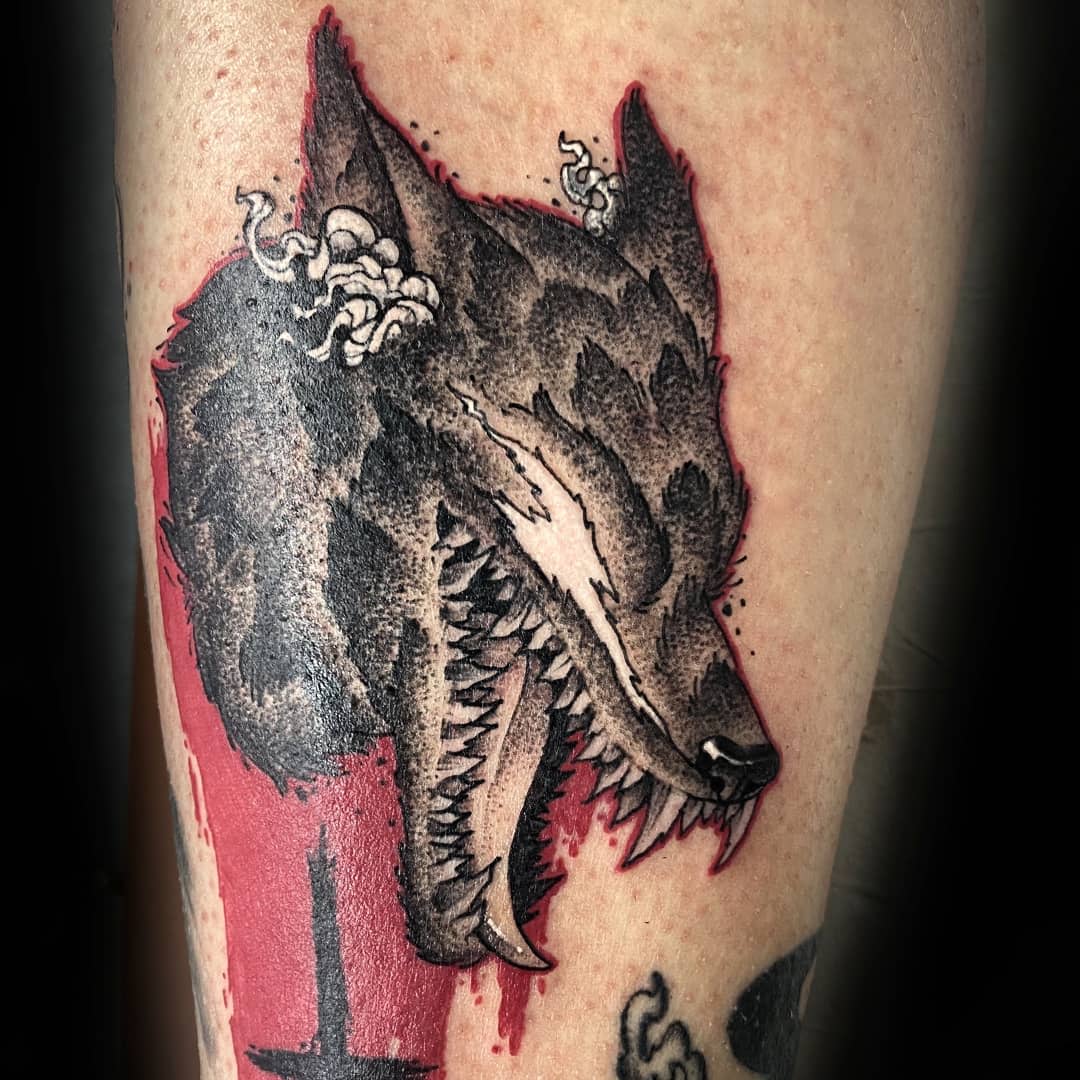 Tattoo of the Berserk Armor's wolf-like form on the arm, depicted with detailed dotwork shading, snarling teeth, and a red background, capturing the ferocity and darkness of the Beast of Darkness