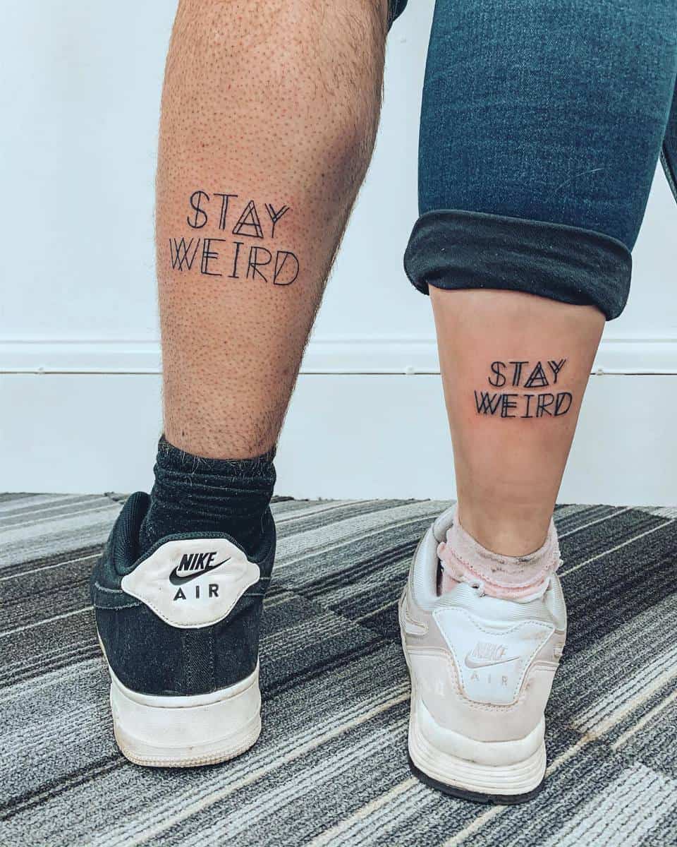 Two people with matching "Stay Weird" tattoos on their legs