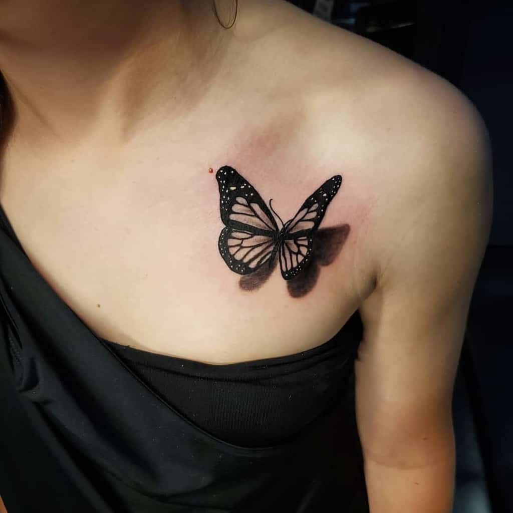 Black butterfly tattoo on the right shoulder