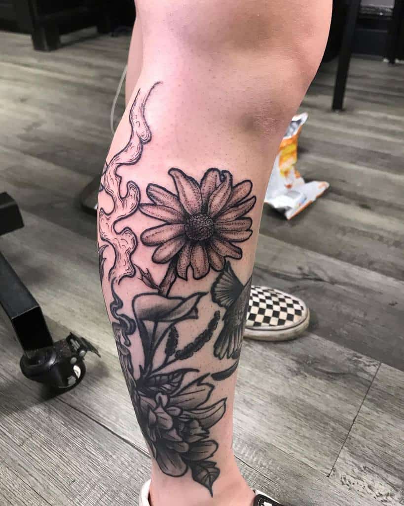 Black and grey leg tattoo of a daisy, beautifully detailed butterfly, and elegant aster