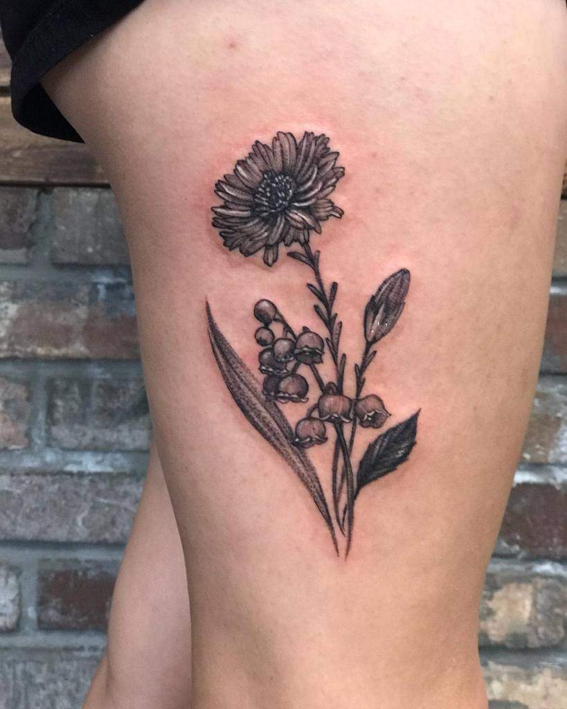 Tattoo of detailed daisy, aster, and lily of the valley flowers on the side of a person's thigh