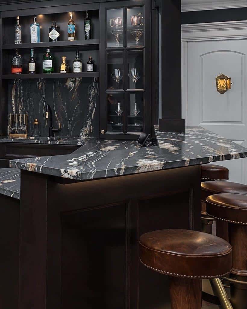 Elegant black marble bar with leather stools, glass cabinets, and liquor display in basement.