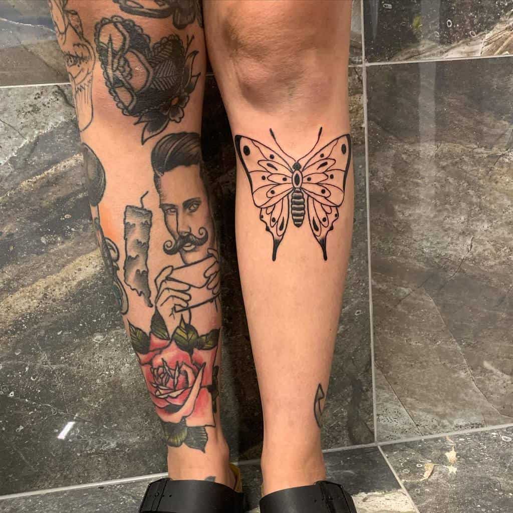Two tattooed legs: one adorned with colorful designs, the other featuring a striking black butterfly tattoo