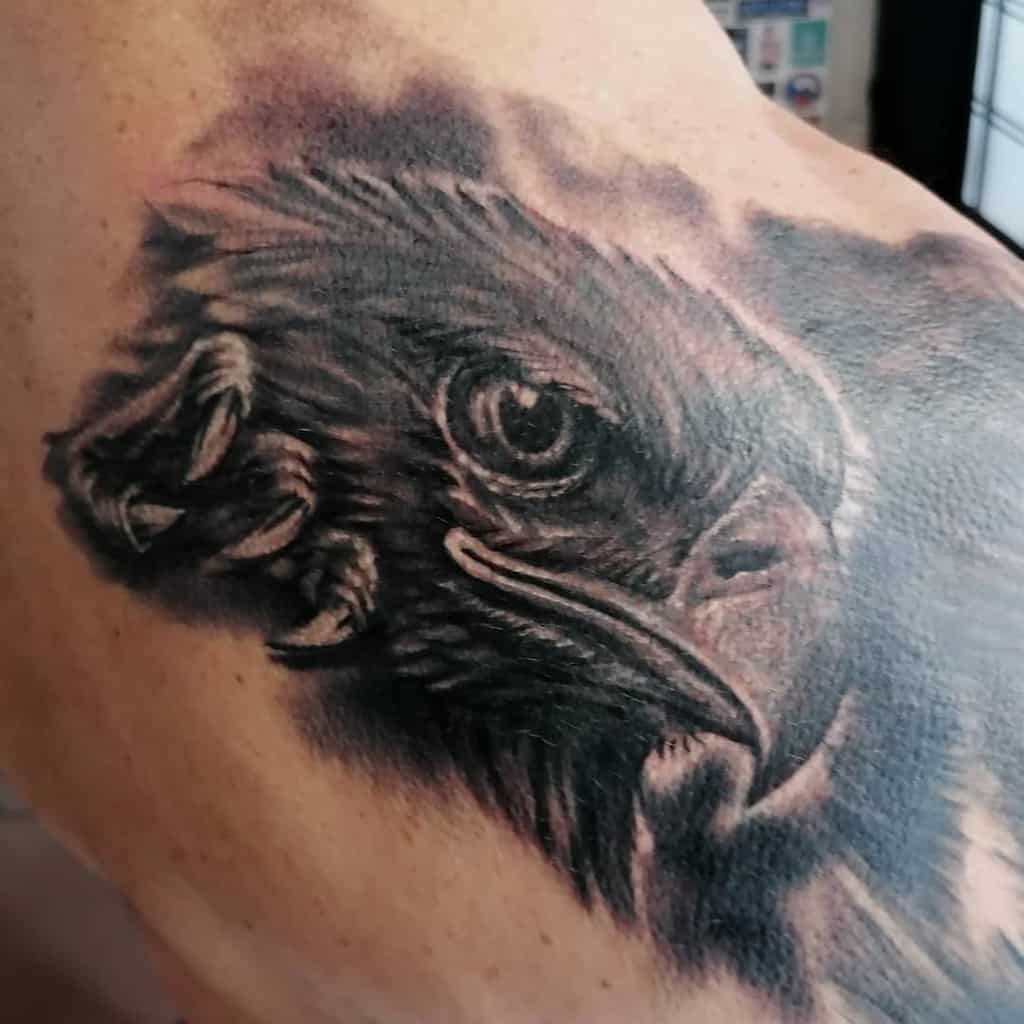 Black and grey tattoo of a detailed eagle head on a shoulder
