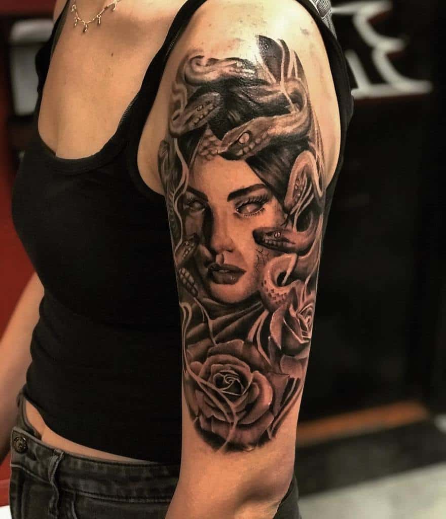 Powerful black-and-grey half-sleeve tattoo of Medusa with intricate snake details and roses, blending beauty and mythology