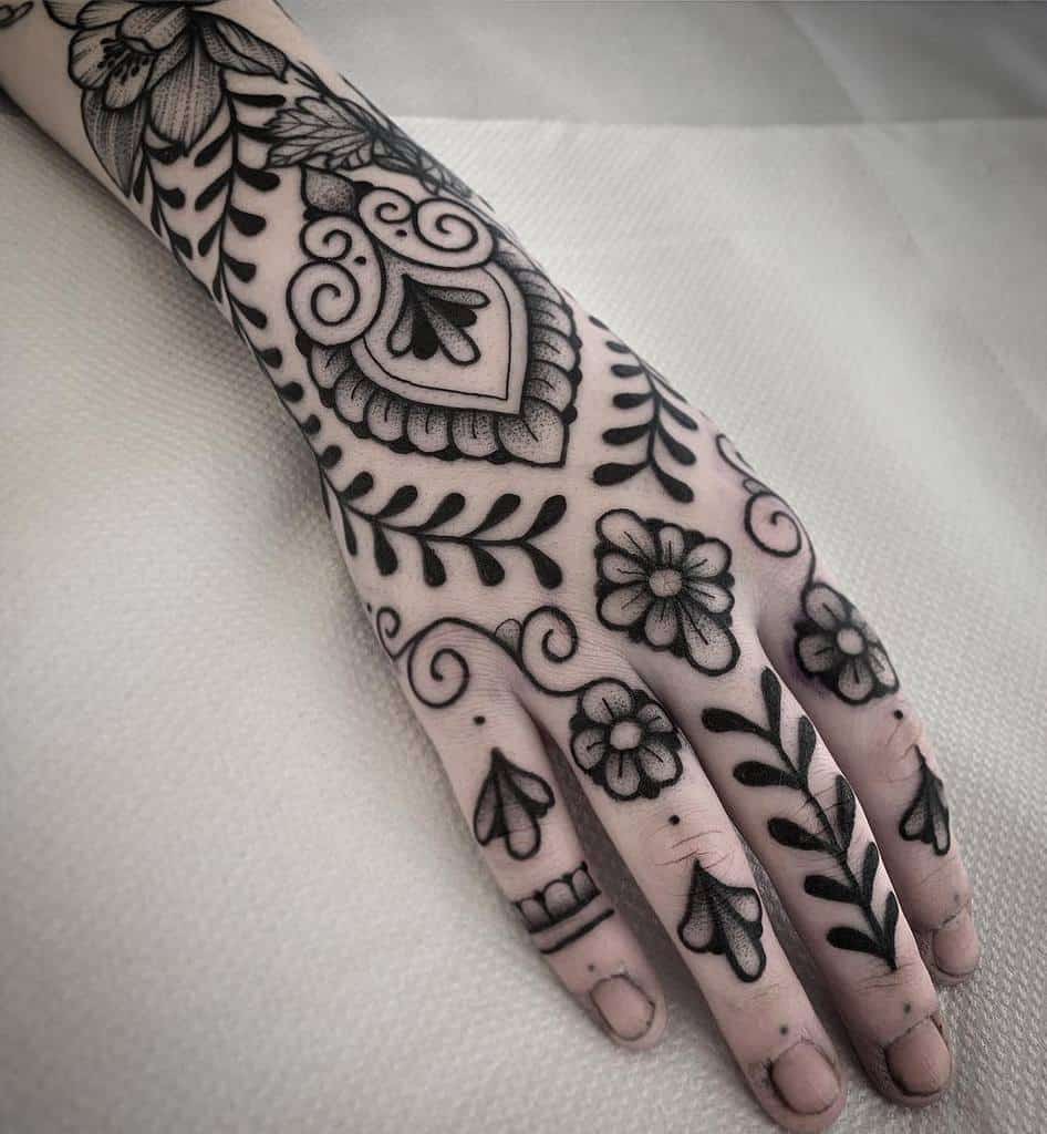 Ornate blackwork tattoo featuring floral, paisley, and vine-like patterns in bold black ink
