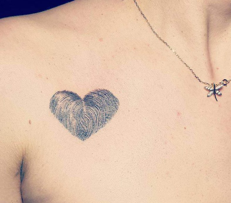 Heart-shaped black tattoo made of fingerprint patterns, symbolizing uniqueness and personal connection