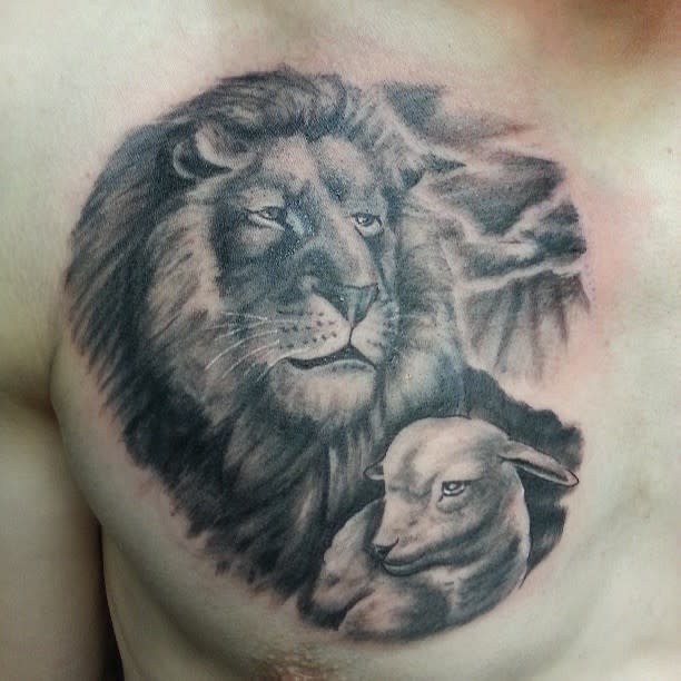 A tattoo of a majestic lion and gentle lamb graces the person's chest