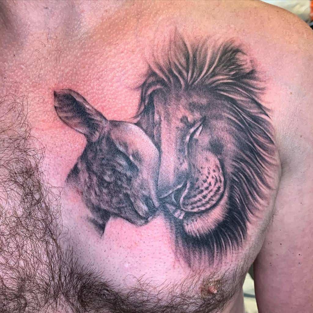 Tattoo of a lion and lamb nuzzling each other on a person's chest