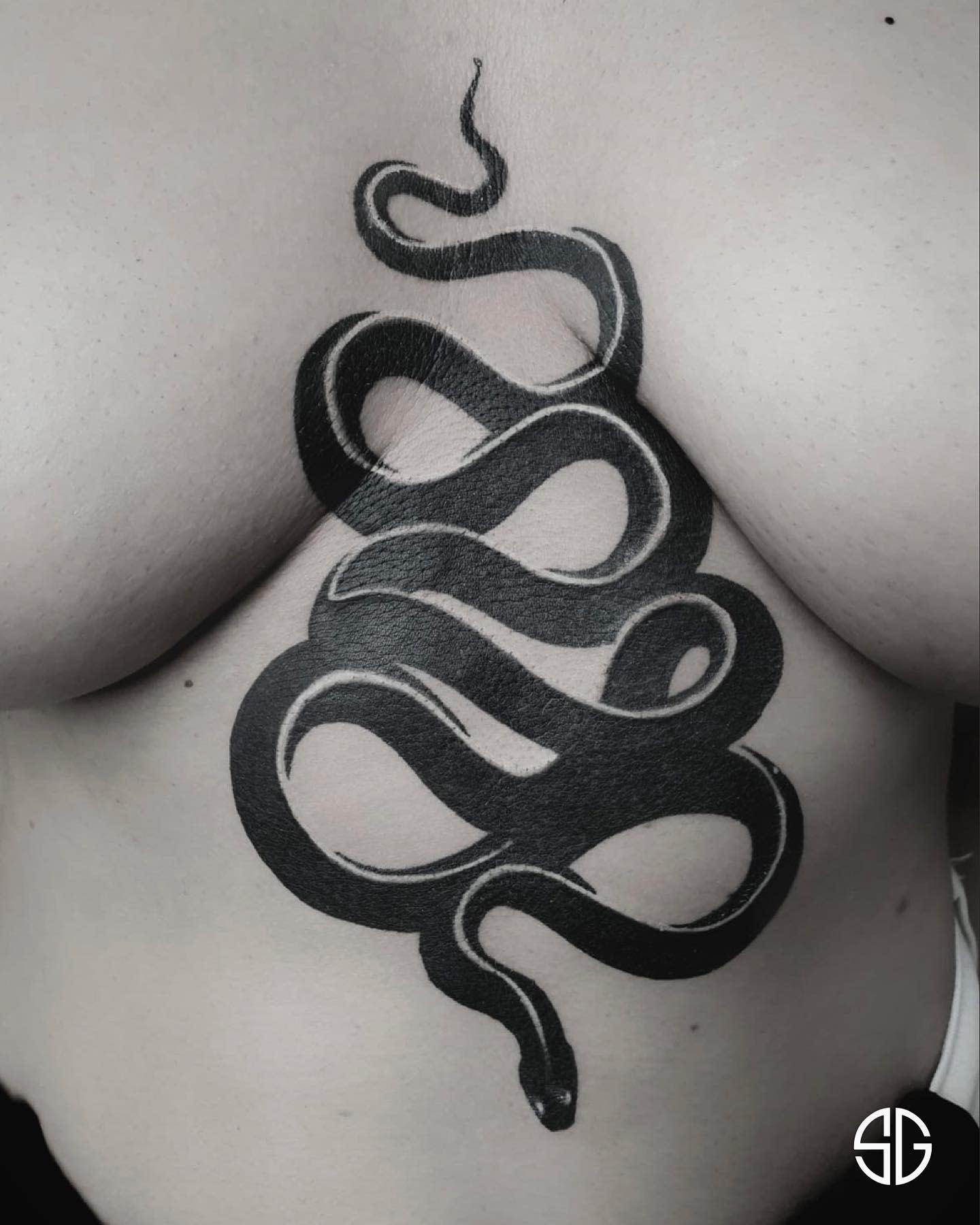 Black mamba tattoo wrapping around the side of a torso