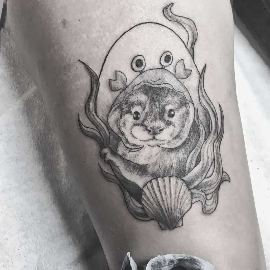 A black and white tattoo of an otter with a shell, surrounded by seaweed, and a ghostly figure adorned with fish fins