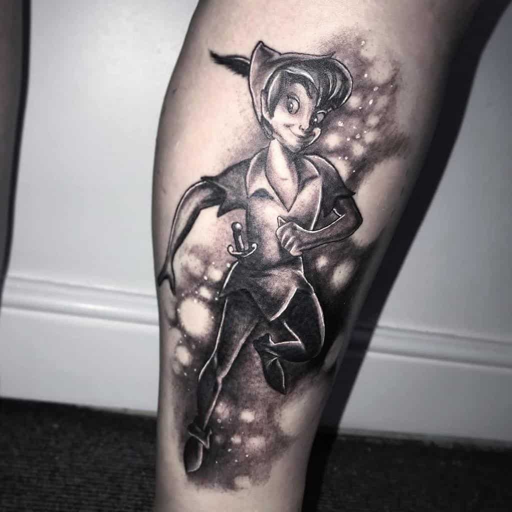 Black and gray Peter Pan tattoo showing him mid-run with a confident smile, detailed shading, and glowing pixie dust accents