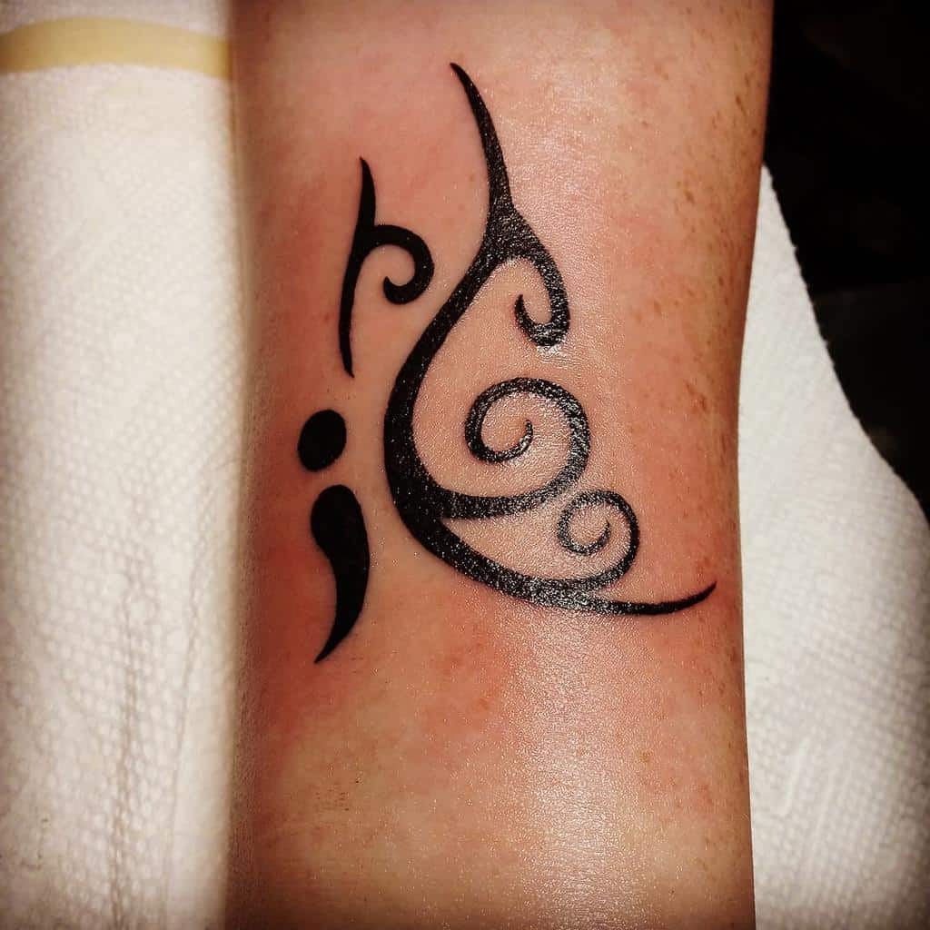 A minimalist black semicolon butterfly tattoo with flowing, abstract lines, symbolizing resilience, mental health awareness, and personal growth