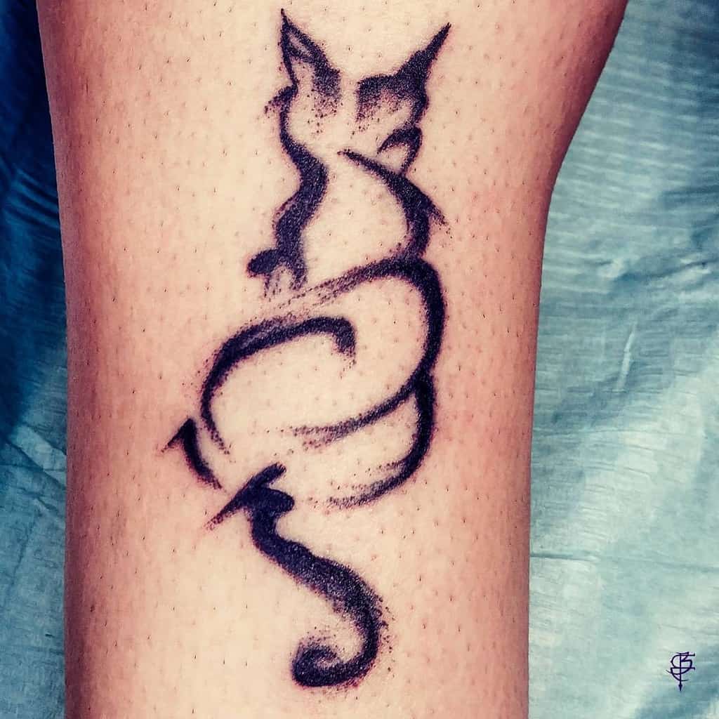 Tattoo of a stylized, abstract black cat design on skin