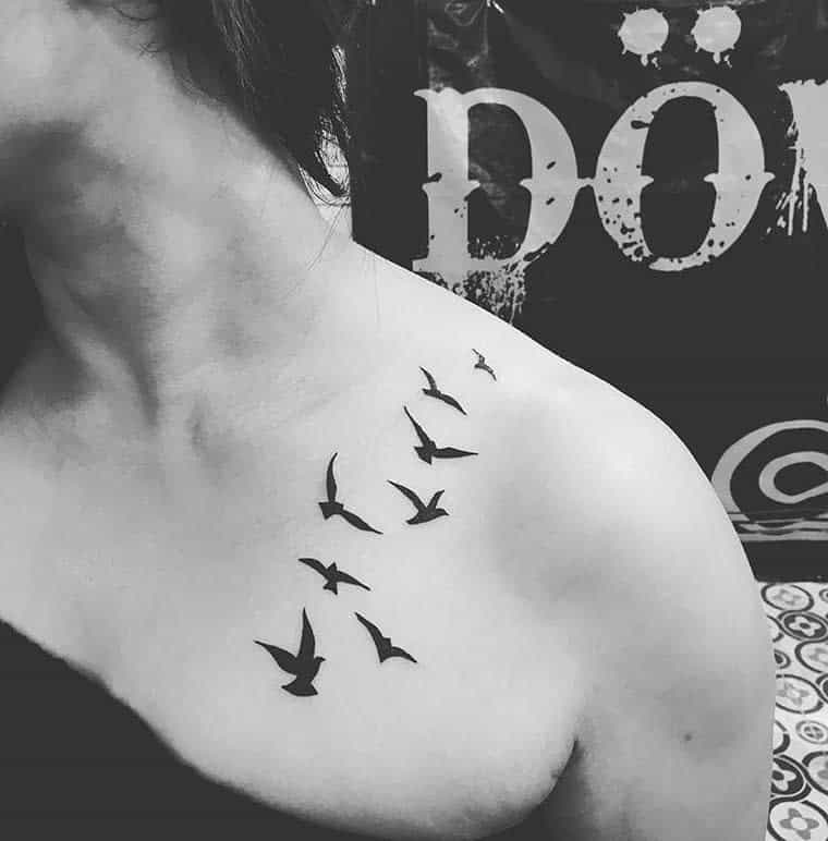 A tattoo of seven flying birds from shoulder to collarbone on the upper chest