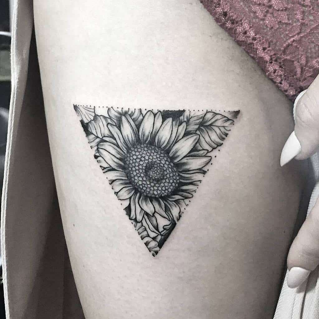 Tattoo of a sunflower inside a triangle on woman's thigh