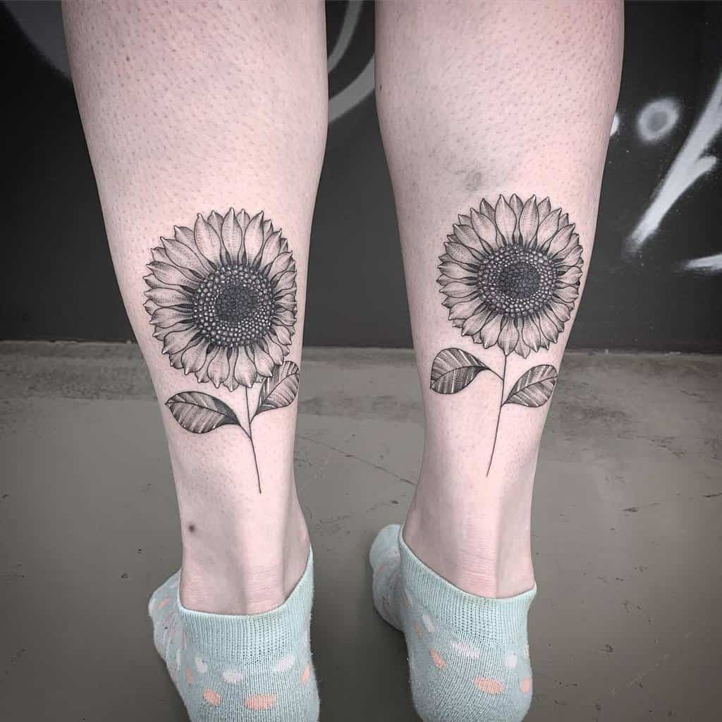 Two detailed sunflower tattoos on calfs